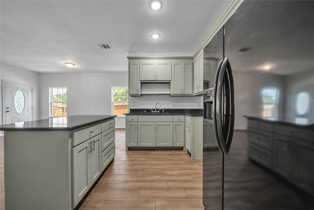 2522 Refugio Ave, Fort Worth, TX 76164 - kitchen featuring fridge with ice dispenser, dark countertops, a kitchen island, wood finished floors, and recessed lighting