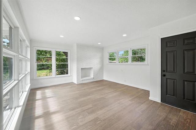 5416 Purington Ave, Fort Worth, TX 76112 - unfurnished living room with ornamental molding, wood finished floors, a brick fireplace, and recessed lighting