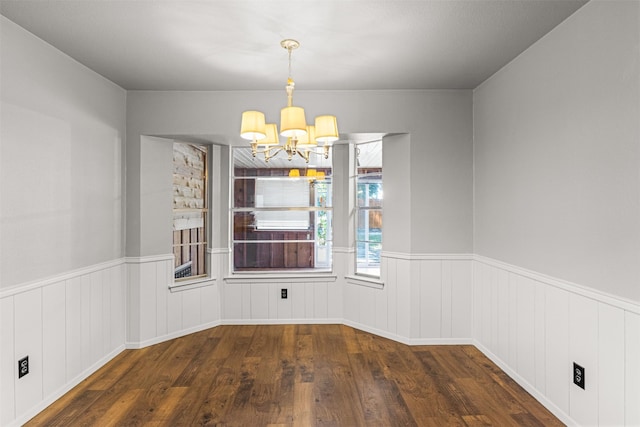 5207 Atlantis Ter, Arlington, TX 76016 - unfurnished dining area with a chandelier, wood finished floors, and a wainscoted wall