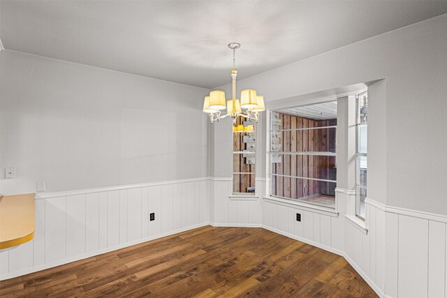 5207 Atlantis Ter, Arlington, TX 76016 - unfurnished dining area with a chandelier, wood finished floors, and a wainscoted wall