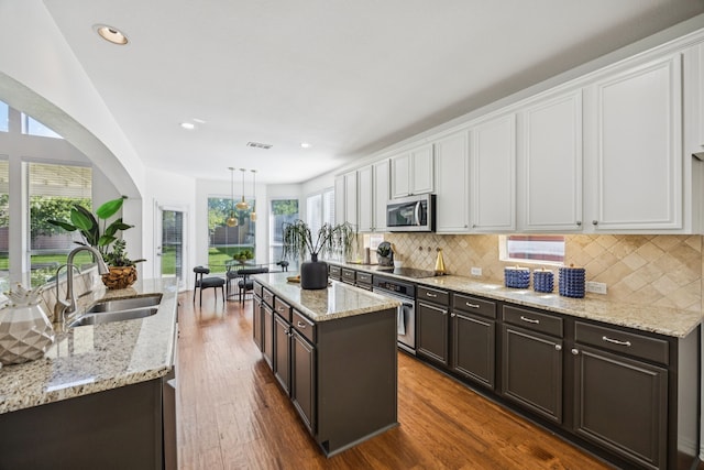 5725 Gerber Ter, Plano, TX 75094 - kitchen with appliances with stainless steel finishes, a kitchen island, white cabinets, tasteful backsplash, and recessed lighting