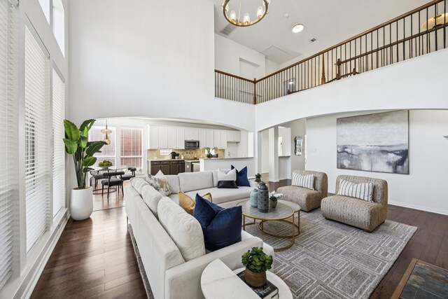 5725 Gerber Ter, Plano, TX 75094 - living area with a chandelier, a high ceiling, dark wood-style flooring, and arched walkways