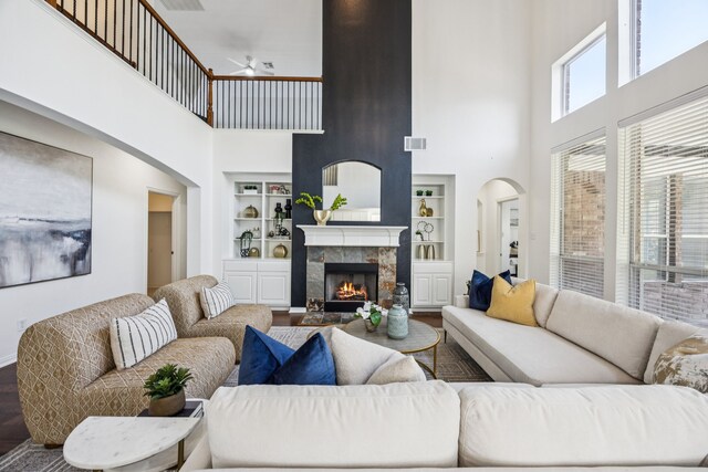 5725 Gerber Ter, Plano, TX 75094 - living room with a towering ceiling, built in shelves, ceiling fan, wood finished floors, and a tile fireplace