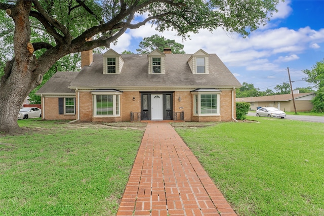 601 N 25th St, Corsicana, TX 75110 - cape cod home featuring a chimney, brick siding, and a front yard