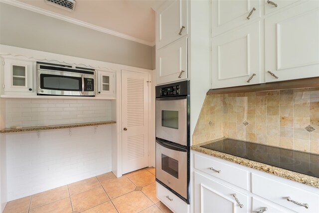 601 N 25th St, Corsicana, TX 75110 - kitchen with appliances with stainless steel finishes, crown molding, white cabinetry, and tasteful backsplash