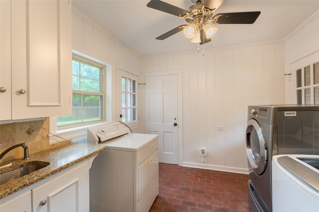 601 N 25th St, Corsicana, TX 75110 - laundry room featuring washer and dryer, brick floors, ornamental molding, ceiling fan, and cabinet space