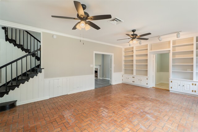 601 N 25th St, Corsicana, TX 75110 - unfurnished living room with ceiling fan, stairway, wainscoting, built in shelves, and brick flooring