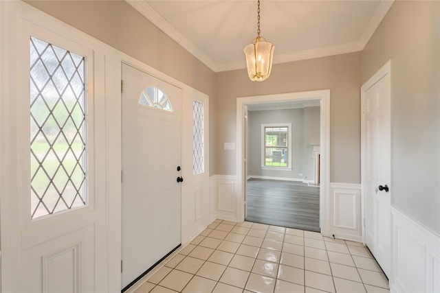 601 N 25th St, Corsicana, TX 75110 - foyer entrance with a decorative wall, light tile patterned floors, a wainscoted wall, ornamental molding, and a chandelier
