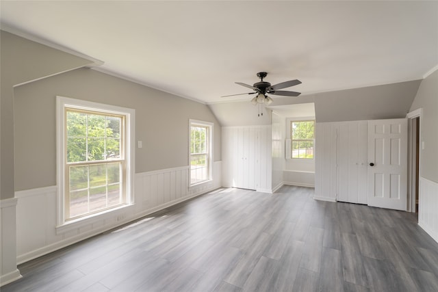 601 N 25th St, Corsicana, TX 75110 - unfurnished bedroom featuring vaulted ceiling, multiple windows, dark wood-type flooring, wainscoting, and a ceiling fan