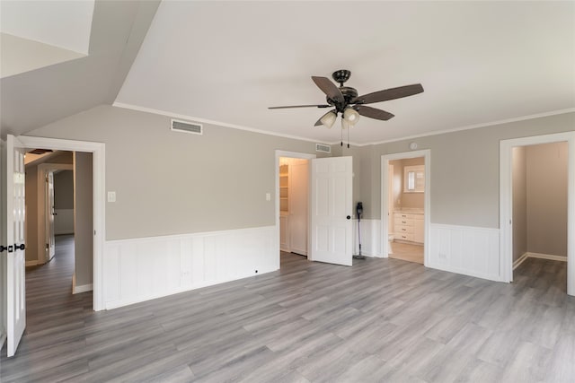 601 N 25th St, Corsicana, TX 75110 - unfurnished bedroom featuring wood finished floors, wainscoting, connected bathroom, a ceiling fan, and ornamental molding