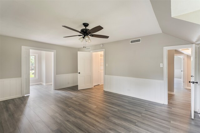 601 N 25th St, Corsicana, TX 75110 - unfurnished room with dark wood-type flooring, a ceiling fan, a wainscoted wall, and lofted ceiling