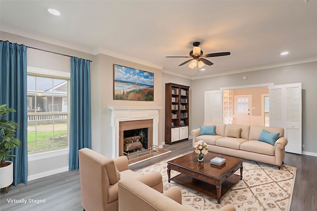 601 N 25th St, Corsicana, TX 75110 - living area featuring ceiling fan, wood finished floors, plenty of natural light, ornamental molding, and a fireplace with raised hearth