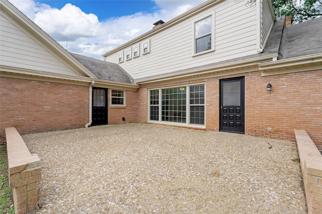 601 N 25th St, Corsicana, TX 75110 - back of house with brick siding, a chimney, and roof with shingles