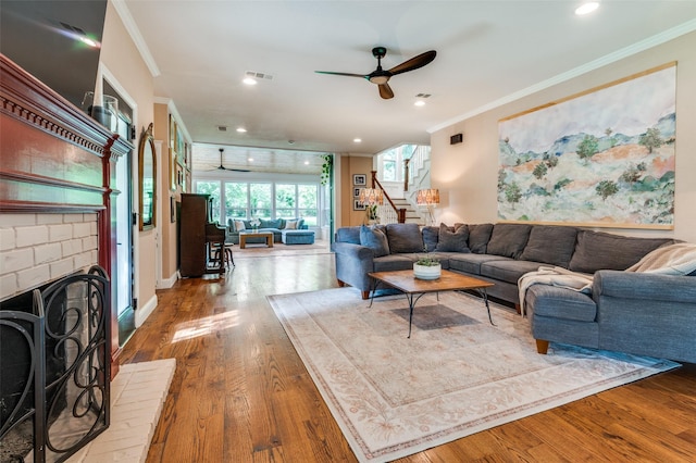 3700 Red Oak Dr, Corinth, TX 76208 - living room featuring ceiling fan, ornamental molding, stairs, wood finished floors, and a brick fireplace