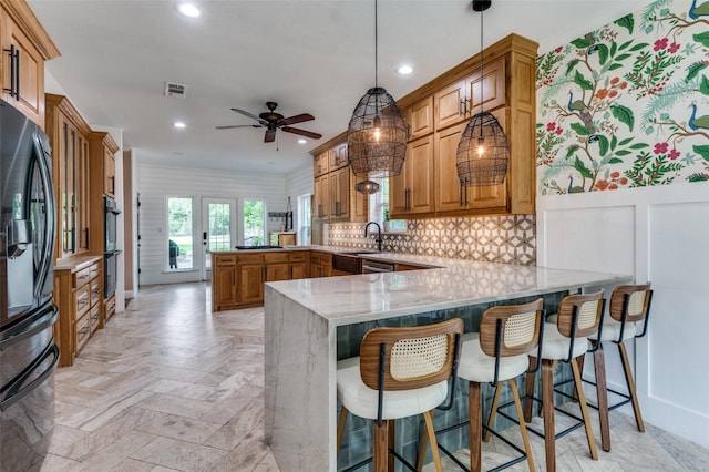 3700 Red Oak Dr, Corinth, TX 76208 - kitchen with a peninsula, black refrigerator, brown cabinetry, a ceiling fan, and recessed lighting