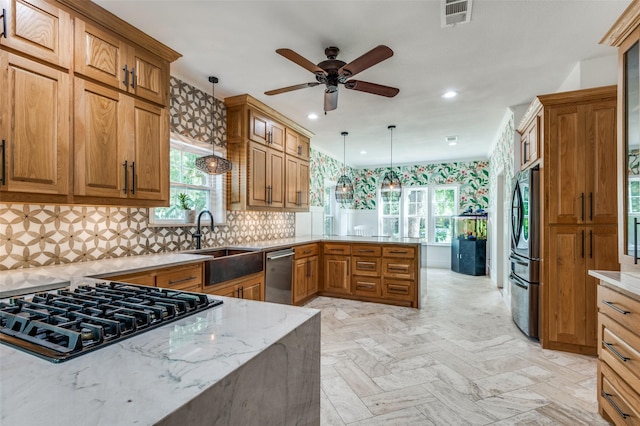 3700 Red Oak Dr, Corinth, TX 76208 - kitchen featuring appliances with stainless steel finishes, a peninsula, brown cabinetry, healthy amount of natural light, and recessed lighting