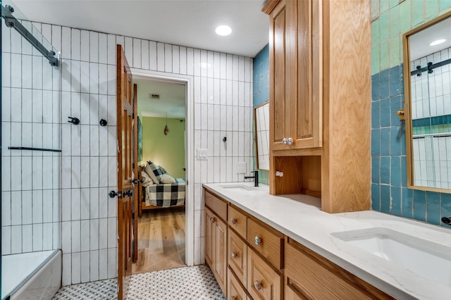 3700 Red Oak Dr, Corinth, TX 76208 - bathroom featuring tile walls, ensuite bathroom, double vanity, tiled shower, and recessed lighting