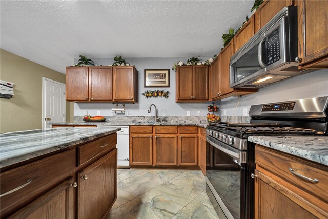 1032 Hampton Dr, Forney, TX 75126 - kitchen with stainless steel appliances, a textured ceiling, light stone counters, and brown cabinetry