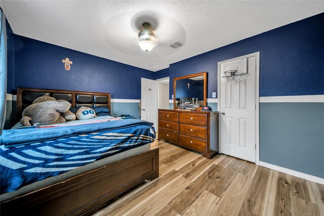 1032 Hampton Dr, Forney, TX 75126 - bedroom featuring a textured wall, a textured ceiling, wood finished floors, and ceiling fan