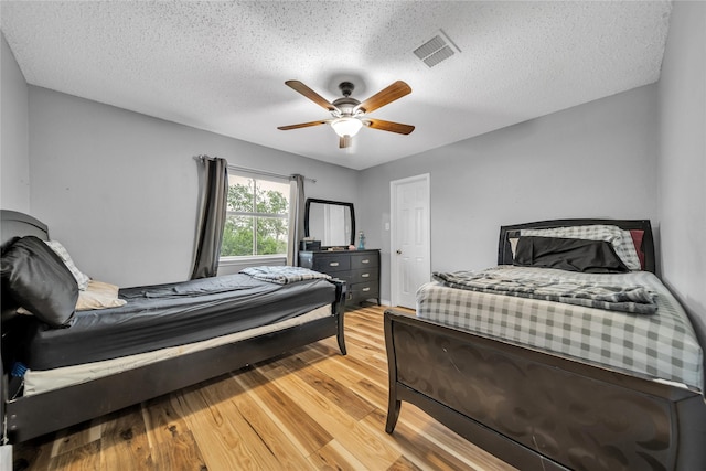 1032 Hampton Dr, Forney, TX 75126 - bedroom featuring light wood-type flooring, a textured ceiling, and ceiling fan