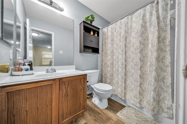1032 Hampton Dr, Forney, TX 75126 - full bath featuring wood finished floors, vanity, a textured ceiling, and a shower with shower curtain