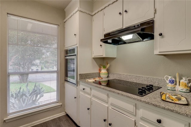 7820 Kermit Ave, Fort Worth, TX 76116 - kitchen featuring under cabinet range hood, black electric stovetop, white cabinets, and light countertops
