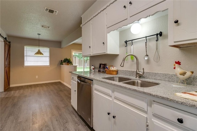 7820 Kermit Ave, Fort Worth, TX 76116 - kitchen with stainless steel dishwasher, a barn door, white cabinets, and a textured ceiling