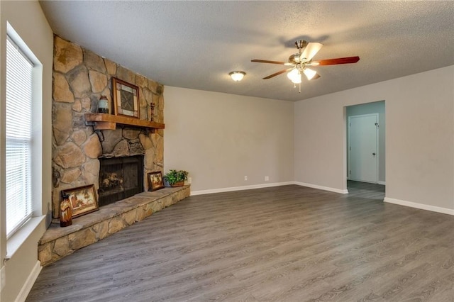 7820 Kermit Ave, Fort Worth, TX 76116 - unfurnished living room with a fireplace, plenty of natural light, a ceiling fan, wood finished floors, and a textured ceiling
