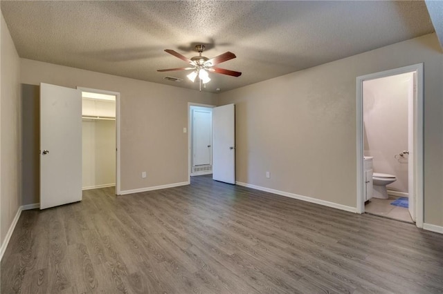 7820 Kermit Ave, Fort Worth, TX 76116 - unfurnished bedroom featuring a textured ceiling, wood finished floors, ensuite bathroom, a closet, and a spacious closet