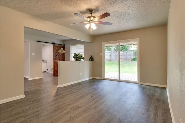 7820 Kermit Ave, Fort Worth, TX 76116 - unfurnished room featuring a barn door, dark wood-style flooring, a textured ceiling, and a ceiling fan