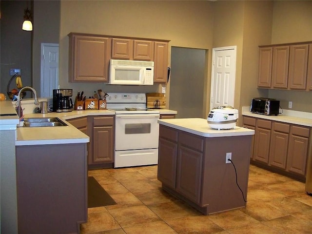 7215 Fossil Hill Dr, Arlington, TX 76002 - kitchen featuring white appliances, a peninsula, light countertops, a center island, and light tile patterned floors