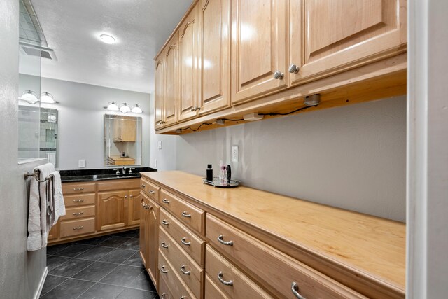 10707 Ferndale Rd, Dallas, TX 75238 - kitchen featuring light brown cabinetry and dark tile patterned flooring