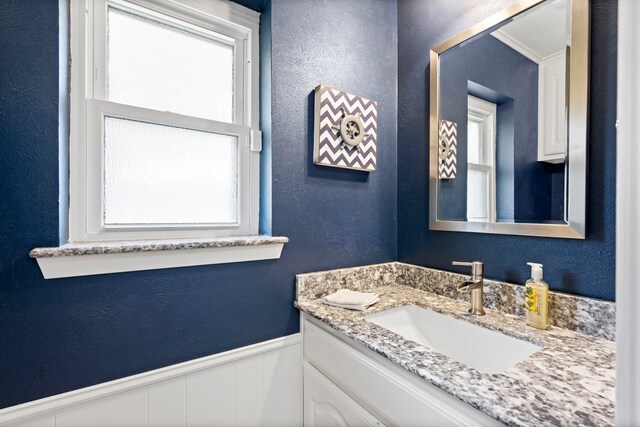 10707 Ferndale Rd, Dallas, TX 75238 - bathroom featuring vanity, a textured wall, and wainscoting