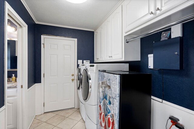 10707 Ferndale Rd, Dallas, TX 75238 - laundry area with washing machine and clothes dryer, cabinet space, a wainscoted wall, light tile patterned flooring, and crown molding