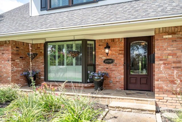 10707 Ferndale Rd, Dallas, TX 75238 - doorway to property with brick siding, roof with shingles, and covered porch