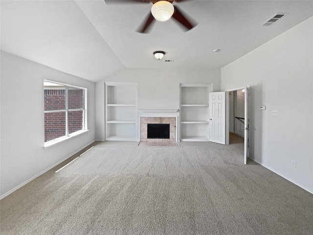 1241 Ducks Lndg, Frisco, TX 75033 - unfurnished living room with built in shelves, carpet floors, ceiling fan, vaulted ceiling, and a tiled fireplace