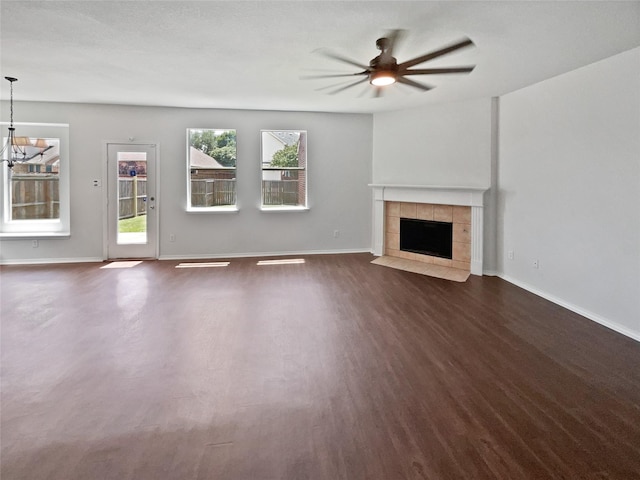 1241 Ducks Lndg, Frisco, TX 75033 - unfurnished living room featuring ceiling fan, dark wood-style flooring, a tile fireplace, and a chandelier