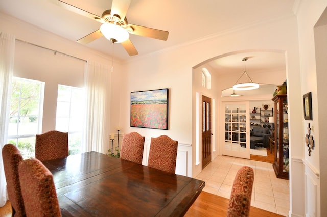 2505 Spring Hill Ln E, Garland, TX 75044 - dining space with arched walkways, crown molding, ceiling fan, and light tile patterned floors