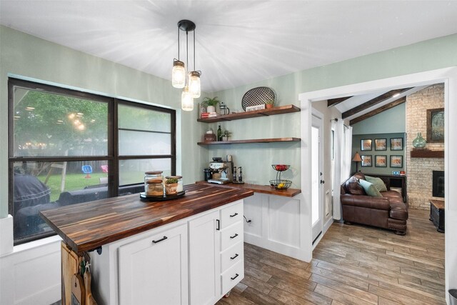 1322 Chestnut Rd, Mansfield, TX 76063 - kitchen featuring butcher block counters, open shelves, wood finished floors, white cabinetry, and a large fireplace
