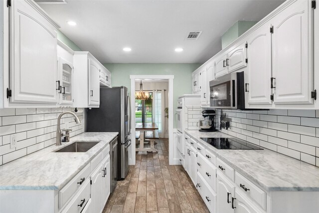 1322 Chestnut Rd, Mansfield, TX 76063 - kitchen with appliances with stainless steel finishes, white cabinetry, a chandelier, backsplash, and recessed lighting