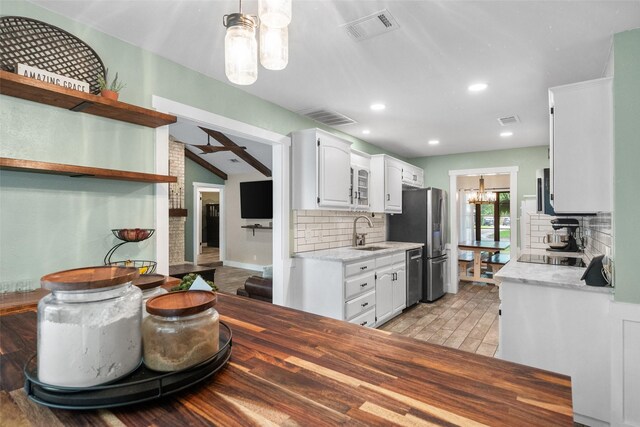 1322 Chestnut Rd, Mansfield, TX 76063 - kitchen with appliances with stainless steel finishes, open shelves, decorative backsplash, white cabinets, and a chandelier