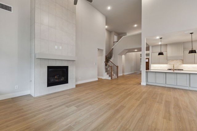 4505 N Summit View Dr, Mckinney, TX 75071 - unfurnished living room featuring recessed lighting, light wood-type flooring, stairway, a ceiling fan, and a tiled fireplace