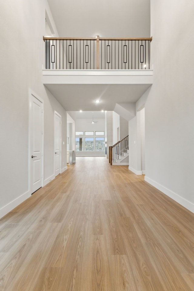4505 N Summit View Dr, Mckinney, TX 75071 - unfurnished living room featuring a high ceiling, wood finished floors, and stairs