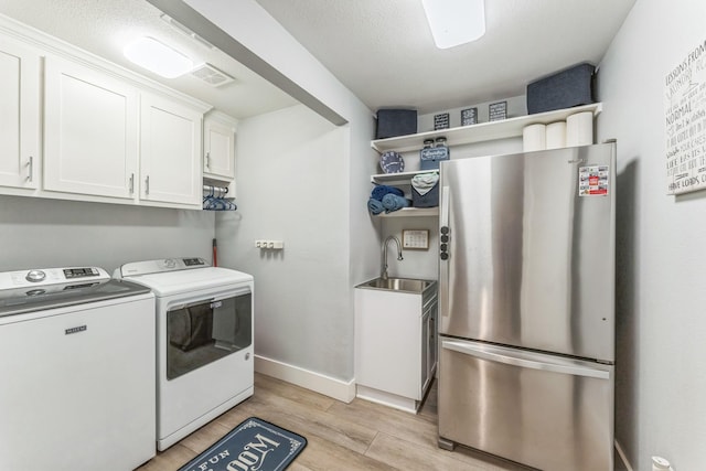 6 Fox Hollow Rd, Joshua, TX 76058 - washroom featuring independent washer and dryer, cabinet space, and light wood-style flooring