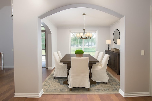 10111 Bluffview Cir, Pilot Point, TX 76258 - dining space with arched walkways, wood finished floors, ornamental molding, and a chandelier