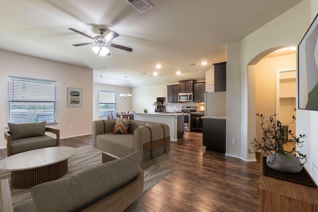 3008 Skinner Dr, Waco, TX 76655 - living area with arched walkways, ceiling fan, dark wood-style flooring, recessed lighting, and a chandelier