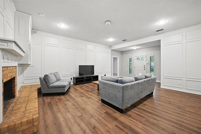 4603 Michelle Dr, Arlington, TX 76016 - living area with a decorative wall, a fireplace, wood finished floors, recessed lighting, and a textured ceiling