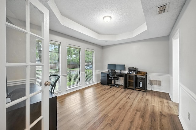 4603 Michelle Dr, Arlington, TX 76016 - office space featuring a textured ceiling, a tray ceiling, wood finished floors, and wainscoting