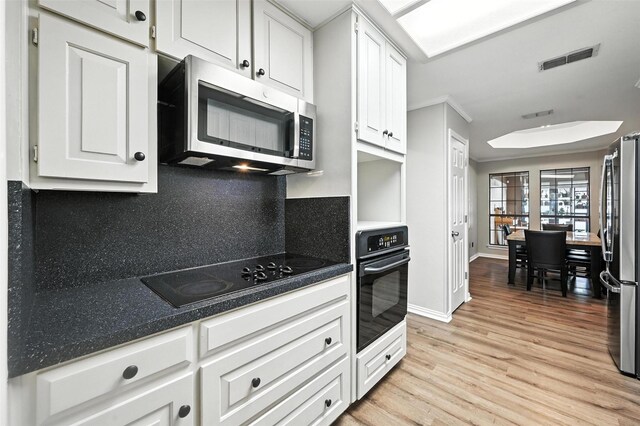 4603 Michelle Dr, Arlington, TX 76016 - kitchen with black appliances, tasteful backsplash, light wood-type flooring, white cabinets, and ornamental molding