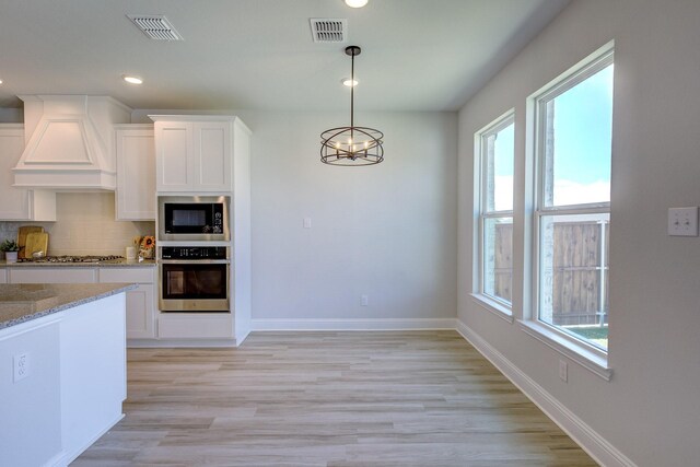 204 Savannah Ln, Oak Point, TX 75068 - kitchen with appliances with stainless steel finishes, premium range hood, plenty of natural light, recessed lighting, and light stone counters